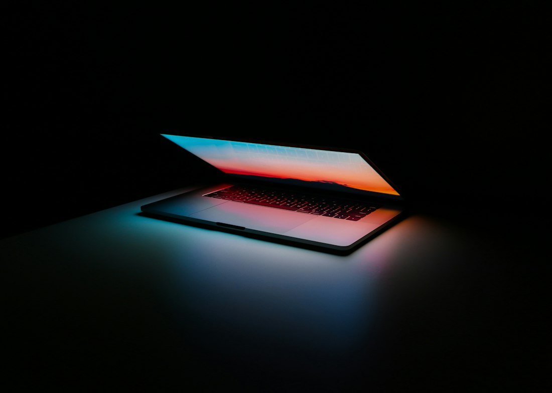 Laptop screen glowing in a dark room
